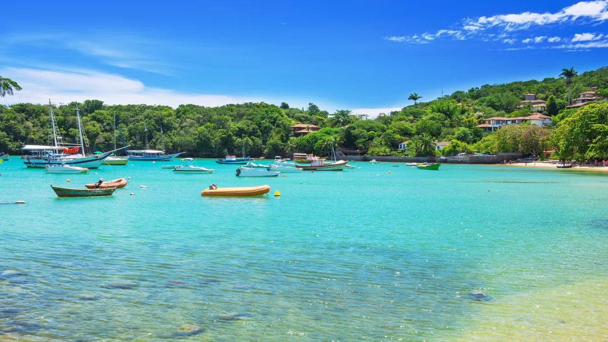 Bahía de Búzios con embarcaciones, agua turquesa y vegetación tropical en la costa.