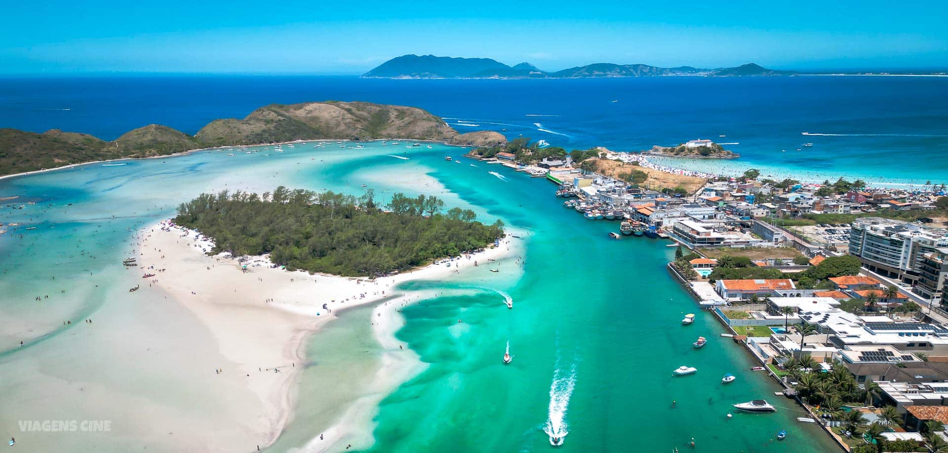 Playa de Cabo Frio con arena blanca, mar turquesa y la ciudad de fondo.